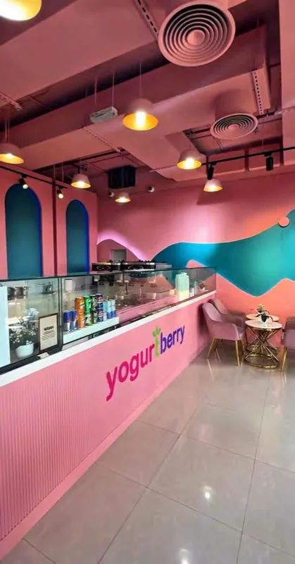 The pink counter and signature teal wave mural inside Yogurtberry